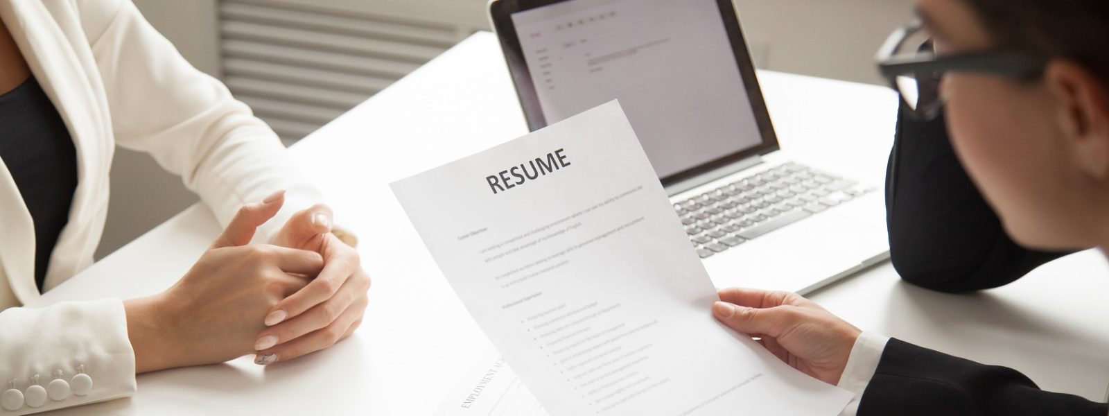 Company representatives reading applicant resume at hiring